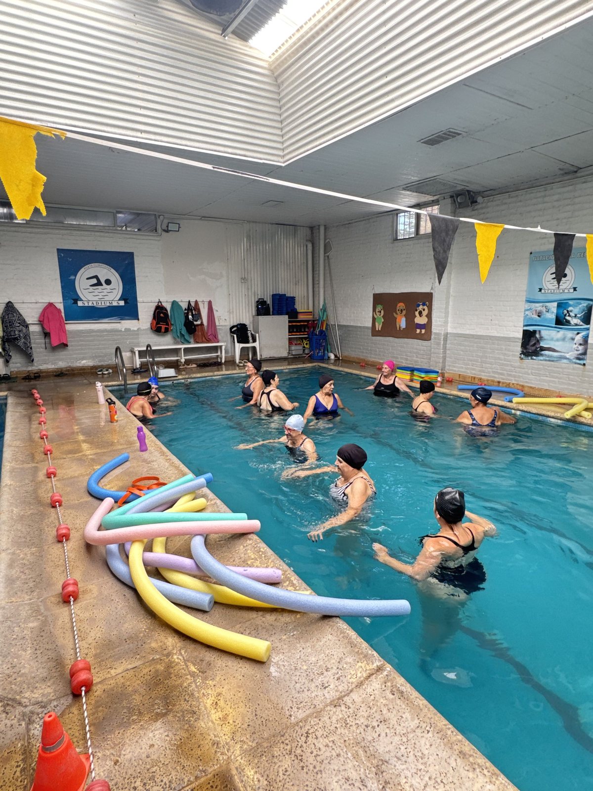 Clase de aquagym con flotadores en la pileta climatizada
